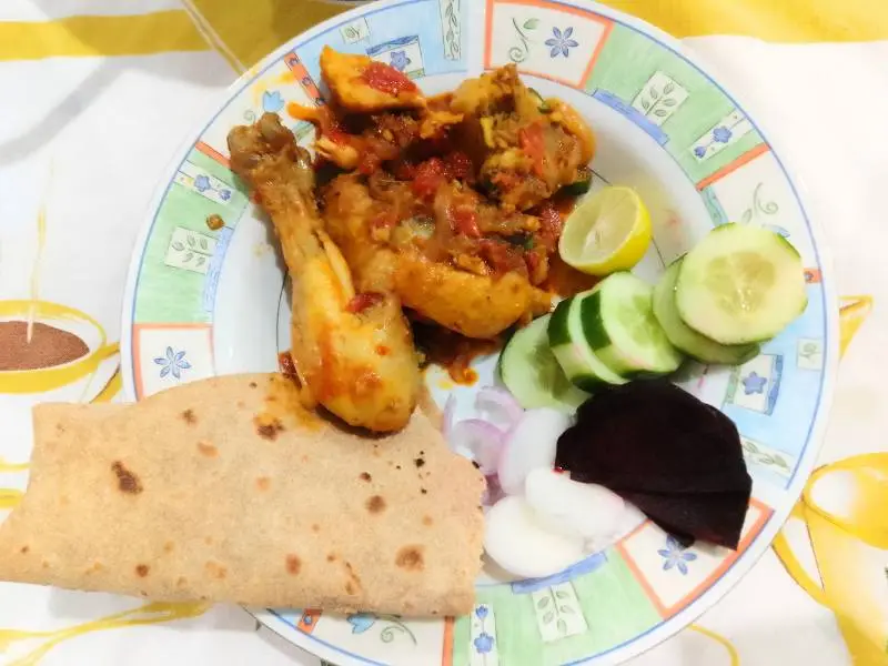Make easy Chicken Karahi at home with simple ingredients. 4 Plate of easy chicken karahi served with roti, cucumber salad, onions, beetroot slices, and lemon